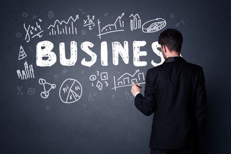 Young businessman in black suit standing in front of a detailed business plan