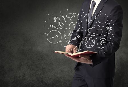 Businessman holding book with doodle drawings and signs.