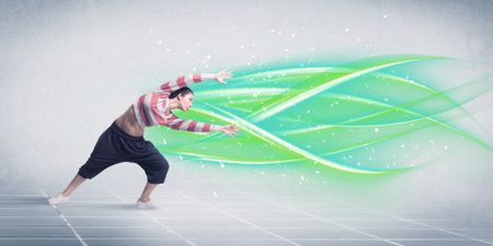 A good looking fresh street dancer dancing in front of grey background with white and bright, colorful green lines concept