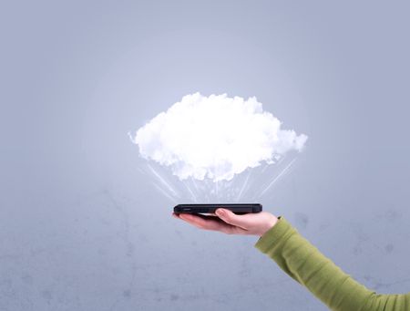 A male hand holding a mobile phone from profile view with an empty white cloud above the device for sales concept