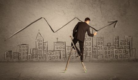 A man in elegant suit standing on a small ladder and drawing a line on brown wall background with buildings