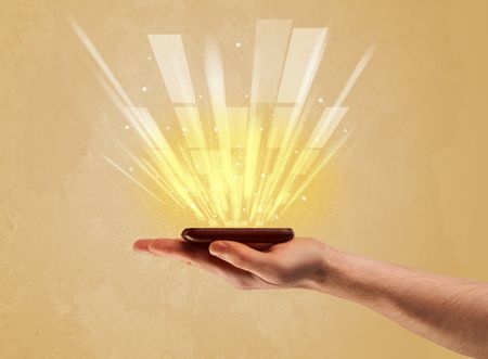 A caucasian hand holding a tablet phone with light beams and information escaping the device illustration concept