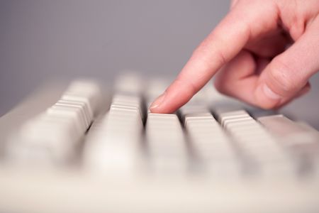 Close up of hand pressing keyboard buttons on desk