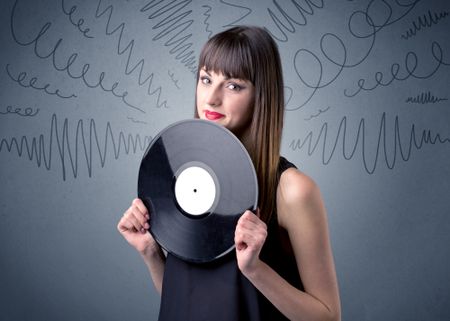 young-lady-holding-vinyl-record-grey-667156378 Young lady holding vinyl record on a grey background with scribbles around her