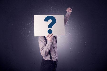 Young businessman hiding behind a question mark drawn on paper 