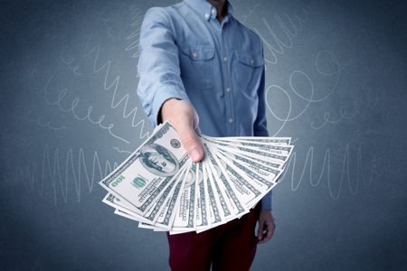 Young businessman holding large amount of bills with grungy background