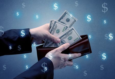 Hand takes out dollar money from a wallet with dollar symbol wallpaper