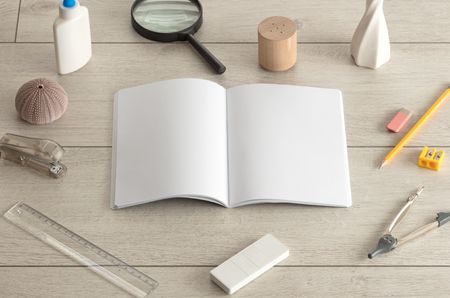 Empty notebook on wood floor with office tools nearby