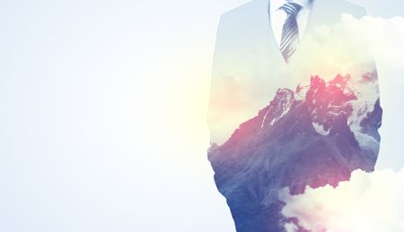 Businessman standing and thinking with snowy mountain graphic