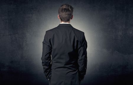 Young businessman standing and thinking alone