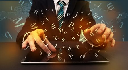 Young man in suit and formal clothing typing with letters around