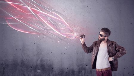 A stylish funny hipster person holding a vintage camera and taking photographs illustrated with glowing red, white lines concept