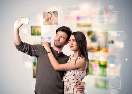 collecting-memories-concept-photos-backbround-happy-670158295 Collecting memories concept with photos in backbround and a happy young couple in love taking selfie with a mobile phone