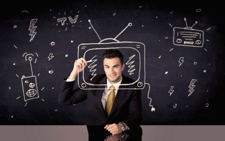 An elegant happy businessman drawing a television around his face, dreaming about becoming a famous actor or a programme presenter concept