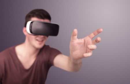 Young impressed man wearing virtual reality goggles