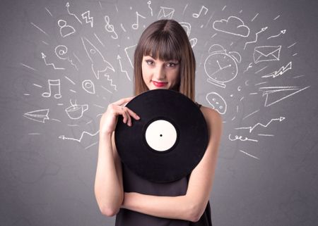 Young lady holding vinyl record on a grey background with mixed scribbles behind her