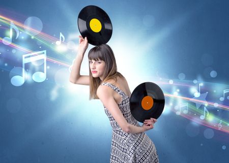 Young lady holding vinyl record on a blue background with musical notes behind her