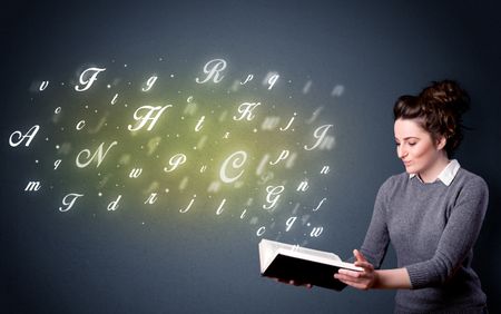 Casual young woman holding book with shiny letters flying out of it