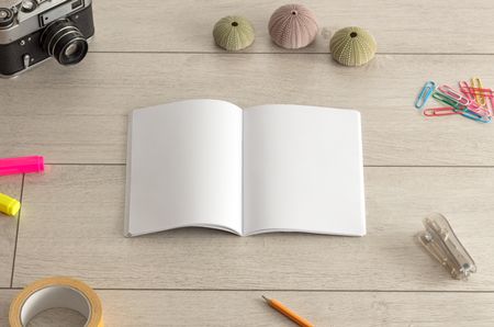 Empty notebook on wood floor with office tools nearby