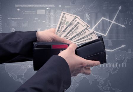 Businessman's hand takes out dollar from wallet with finance graphic on the background
