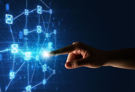 Female finger touching a beam of light surrounded by a blue graphic with envelopes