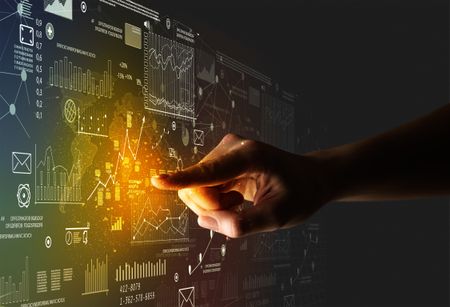 Female finger touching a beam of light surrounded by charts and graphs