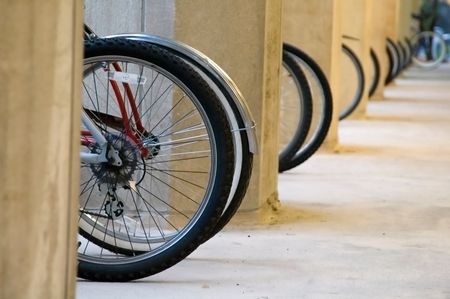 Wheels of bicycles parked by university building