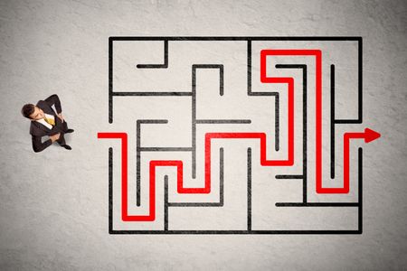 Lost businessman found the way in maze with red arrow on grungy background