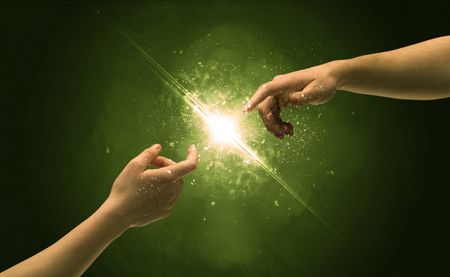 two-naked-male-hands-touch-lighting-672702568 Two naked male hands about to touch, lighting the spark with modest explosion in front of green background concept