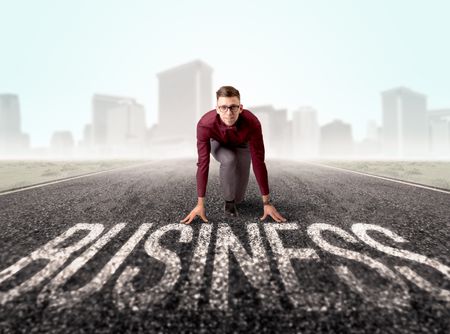 Young determined businessman kneeling before business text