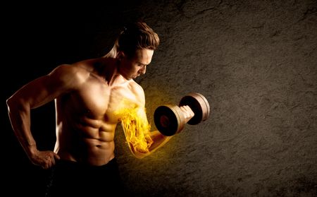 Muscular bodybuilder lifting weight with flaming biceps concept on background
