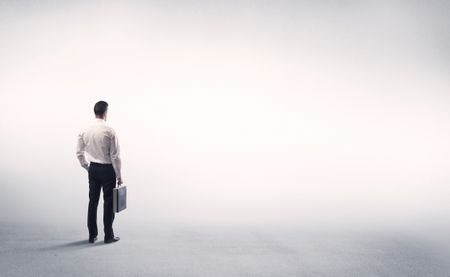 Corporate business male in modern suit standing in big blank empty grey space concept