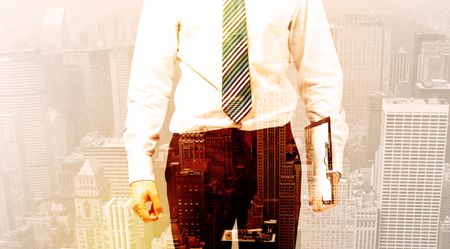 Business man looking at warm overlay city background