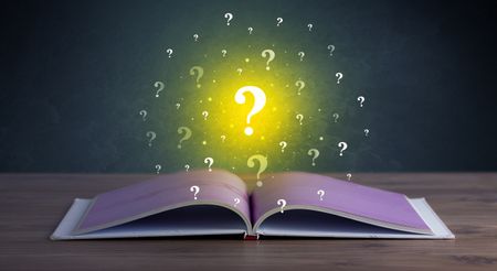 Yellow question marks hovering over open book