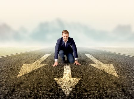 Young determined businessman kneeling before three arrows