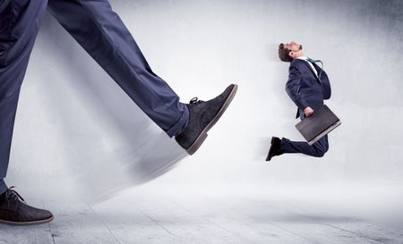 Giant leg kicking small businessman and he is flying away
