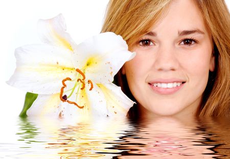 healthy girl smiling portrait holding a lily flower next to her face - isolated over a white background