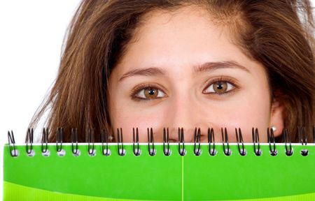 college student peeking over a green notebook over a white background