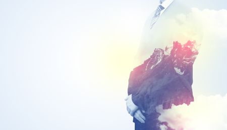 Businessman standing and thinking with snowy mountain graphic