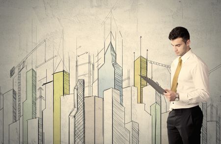 A young adult businessman standing in front of a wall with colorful drawings of buildings, charts, graphs, signs