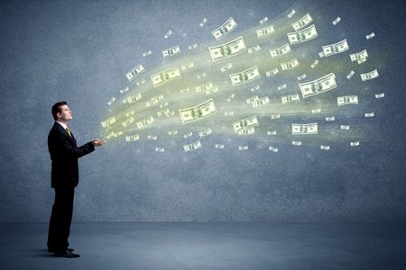 Caucasian male in business suit holding money,which flies through his hands