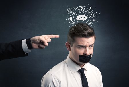 Caucasian business hand pointing at stressed male employee with drawn question, explamation marks, talk bubble above his head