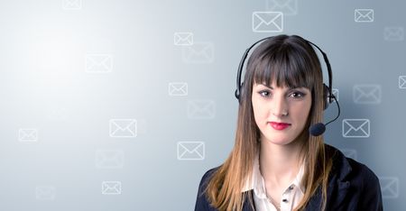 Young female telemarketer with white envelopes surrounding her 