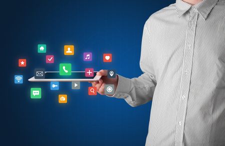 Casual businessman holding tablet with colorful applications 