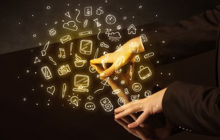 Male hands touching interactive table with yellow mixed media icons on it