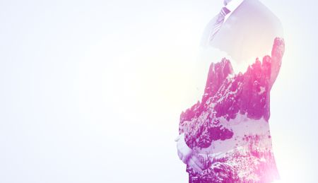 young-businessman-suit-standing-sunny-snowy-678054199 Young businessman in suit standing with sunny snowy mountain and trees graphic.