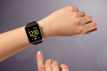Naked female hand with smart wristwatch and digital clock on the screen 