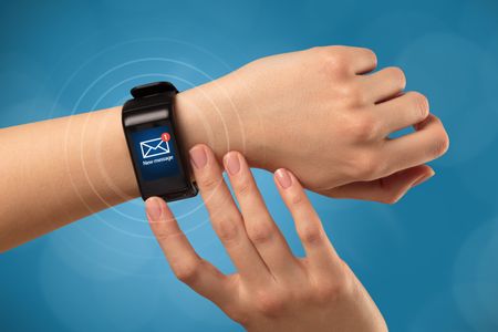 Female hand receives new message on her smartwatch