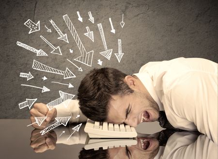 An exhausted business person resting his head on keyboard with pressure illustrated by arrows pointing at him concept