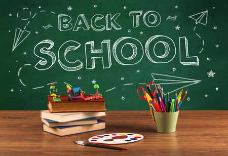 Back to school concepty with writing on blackboard and desk, apple, books, items